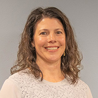 Gina is of light complexion with shoulder length brown hair.