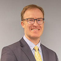 Ariel is of fair complexion with short brown hair and wears glasses.